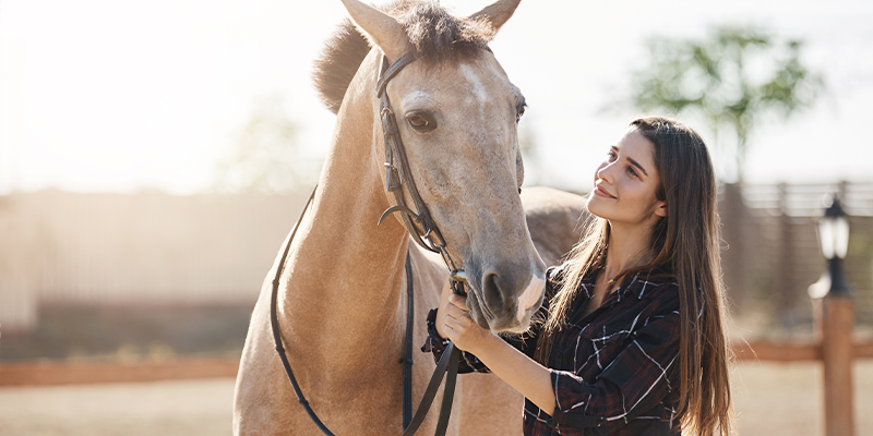 A woman staring lovingly at her horse.